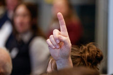 Bild einer gehobenen Hand in einer Personengruppe