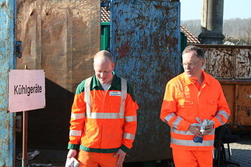 Matthias Schulz, Mitarbeiter beim OsnabrückerServiceBetrieb und Ministerpräsident Stephan Weil (rechts) in Arbeitskleidung vor Containern