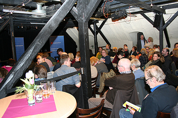 Blick von hinten links über die Teilnehmenden am Bürgerforum Richtung Podium