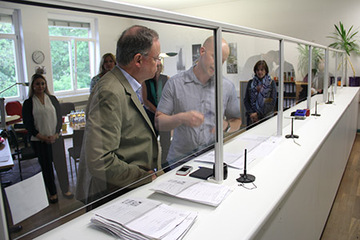 Ministerpräsident und ein Mitarbeiter der Landesaufnahmebehörde am Tresen