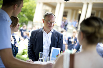 Ministerpräsident im Garten des Gästehauses der Landesrierung an einem Stehtisch mit mehreren Jugendlichen