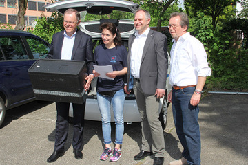 Gruppenbild vor dem Einsatzfahrzeug; der Ministerpräsident hält eine Essensbox in den Händen