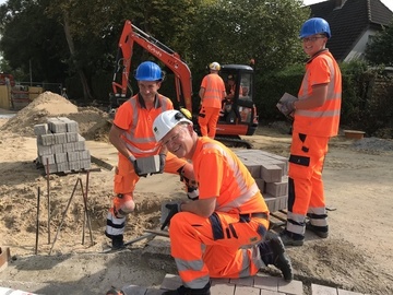 Teamwork Stephan Weil und Kollegen: Steine setzen für die Straßenrinne