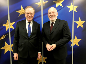 Ministerpräsident Stephan Weil mit dem Ersten Vizepräsidenten der Kommission Frans Timmermans vor einer Europa-Flagge.