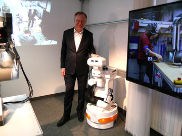 Künstliche Intelligenz und Robotik beim DFKI in Osnabrück; Ministerpräsident Weil steht neben einem Roboter
