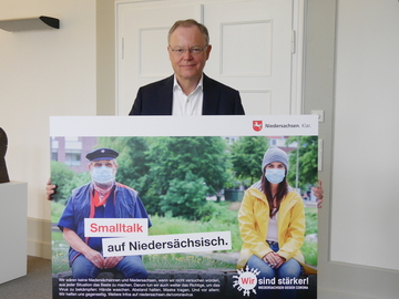 Ministerpräsident Stephan Weil präsentiert ein Plakat aus der Kampagne „Wir sind stärker! Niedersachsen gegen Corona“ (Juli 2020)