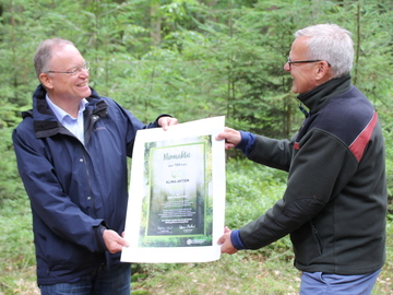 Dr. Klaus Merker (Präsident der Nds. Landesforsten) übergibt die Klimaaktie an Ministerpräsident Weil