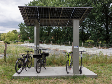 Ladestation und Biolandwirtschaft (im Hintergrund) beim Permakulturpark