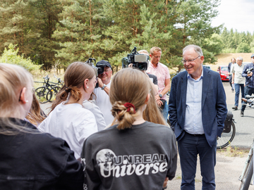 Stephan Weil im Gespräch mit Schülerinnen und Schülern auf dem Gelände der Eickhofer Heide