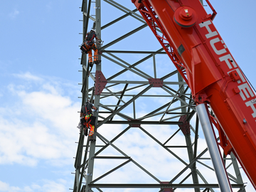 Industriekletterer klettern den fertig errichteten Mast hinunter