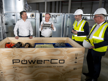 Vorstand Thomas Schmall (links) und Ministerpräsident Stephan Weil entpacken neue Maschinenteile für die Batteriezellenproduktion