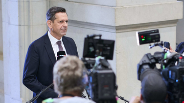 Ministerpräsident Olaf Lies spricht zu Journalistinnen und Journalisten. Im Vordergrund sind Kameras und Mikrofone zu sehen, im Hintergrund die Marmorfassade des Bundesrats.