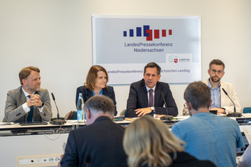 Finanzminister Gerald Heere, Kultusministerin Julia Hamburg, Ministerpräsident Olaf Lies und Niklas Kleinwächter sitzen auf dem Podium der Niedersächsischen Landespressekonferenz. Im Vordergrund sind Journalistinnen und Journalisten zu sehen.