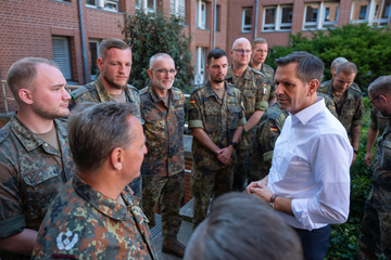 Ministerpräsident Olaf Lies steht im Kreis mit Soldaten Soldaten und unterhält sich