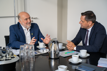 Ministerpräsident Lies sitzt an einem Tisch mit Kaffeegedeckt im Gespräch mit dem Botschafter von Israel in der Bundesrepublik Deutschland, Ron Prosor