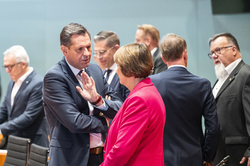 Ministerpräsident Lies im Gespräch mit der Präsidentin des Verbandes der Automobilindustrie (VDA). Im Hintergrund sind verschiedene Menschen zu sehen, die sich zum Teil ebenfalls unterhalten.