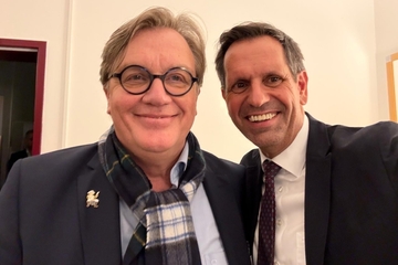 Hape Kerkeling steht neben Ministerpräsident Lies, beide machen ein Selfie und lachen in die Kamera.