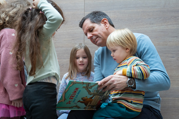 Der Ministerpräsident liest Kindern ein Buch vor.