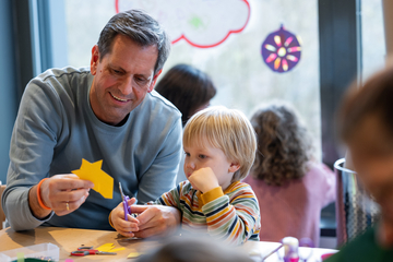 Olaf Lies bastelt mit einem Kind.