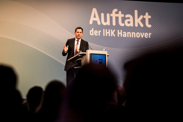 Der Ministerpräsident Olaf Lies steht an einem Rednerpult vor dem blauen Hintergrund mit der Aufschrift ,,Auftakt der IHK Hannover