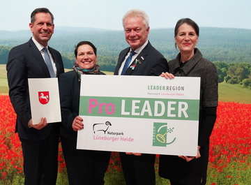 Ministerpräsident Olaf Lies, Europa- und Regionalentwicklungsministerin Melanie Walter und Landwirtschaftsministerin Miriam Staudte übergeben ein Positionspapier an Bundeslandwirtschaftsminister Alois Rainer. Alle stehen in einer Reihe.