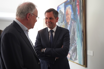 Ministerpräsident a.D. Weil und Ministerpräsident Olaf Lies stehen vor dem enthüllten Portrait von Weil