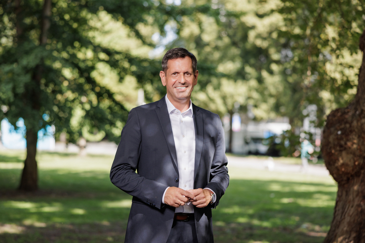 Ministerpräsident Olaf Lies steht auf einer grünen Wiese und schaut freundlich in die Kamera.