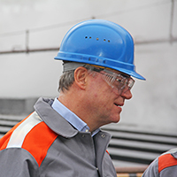 Porträt von Stephan Weil in Arbeitskleidung mit Helm