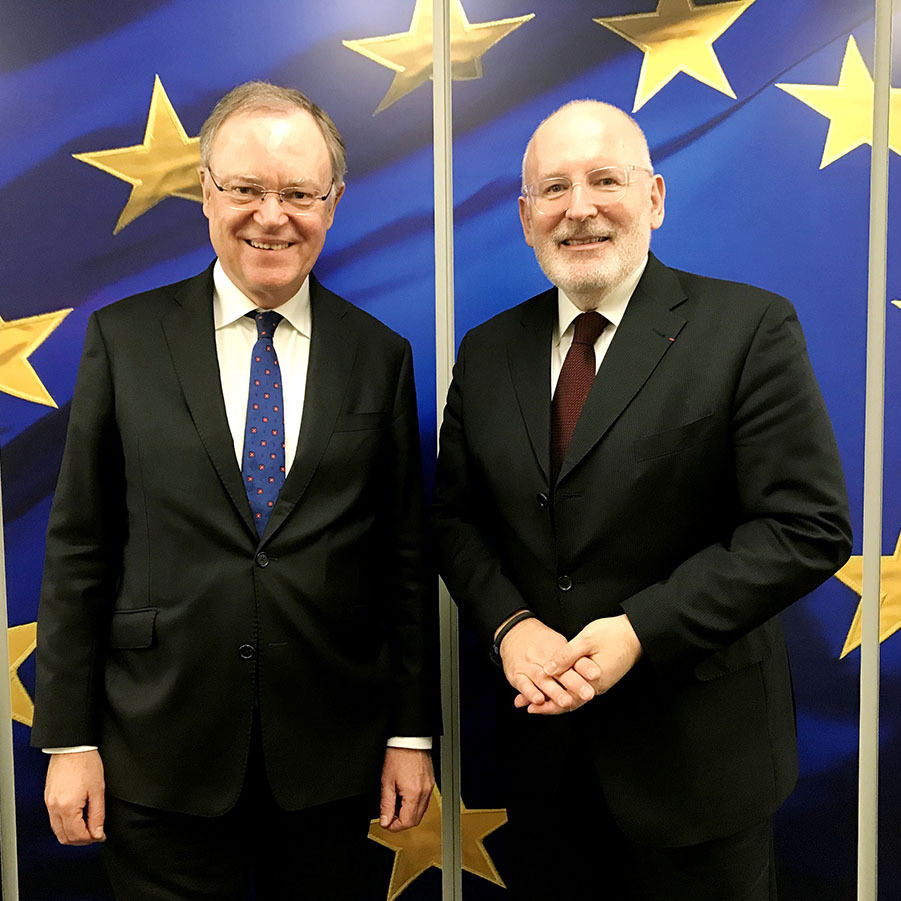 Ministerpräsident Stephan Weil mit dem dem Ersten Vizepräsidenten der Kommission Frans Timmermans vor einer Europa-Flagge.
