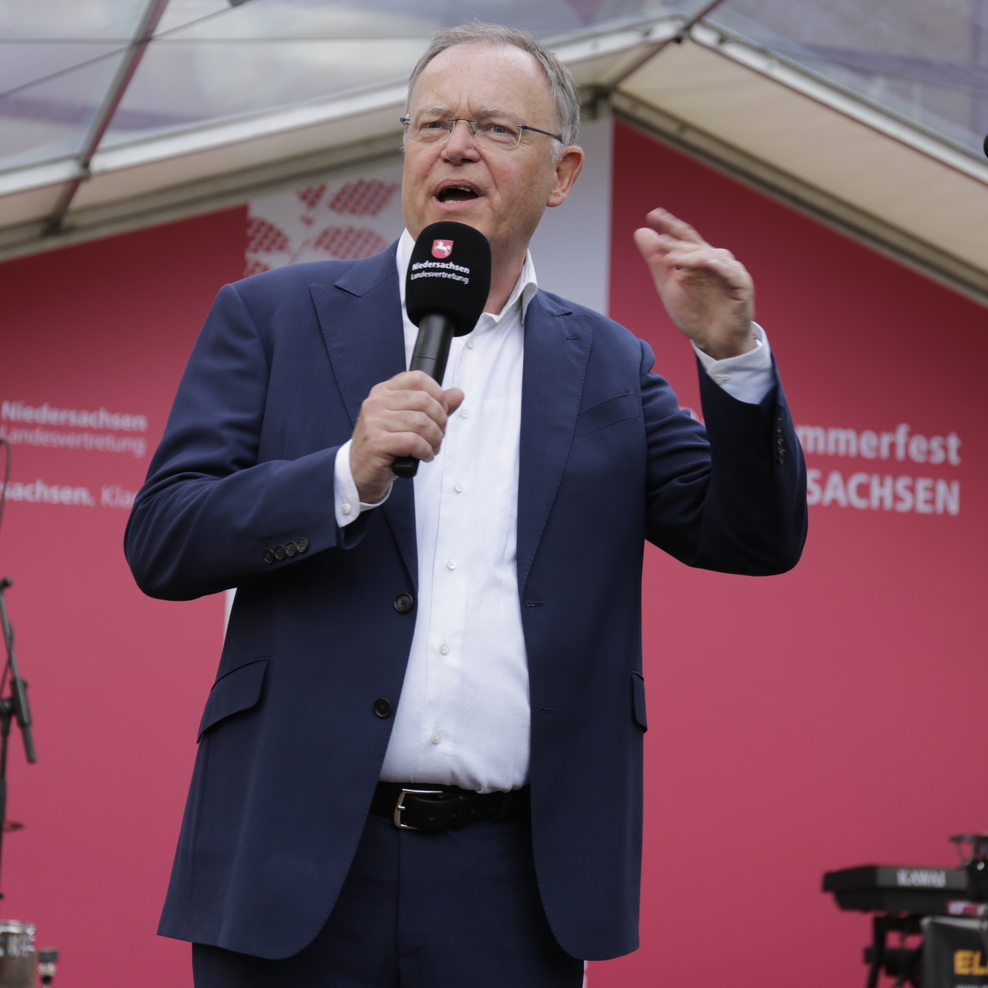 Ministerpräsident Stephan Weil steht mit einem Mikrofon in der Hand auf der Bühne beim Sommerfest in der Landesvertretung in Berlin.