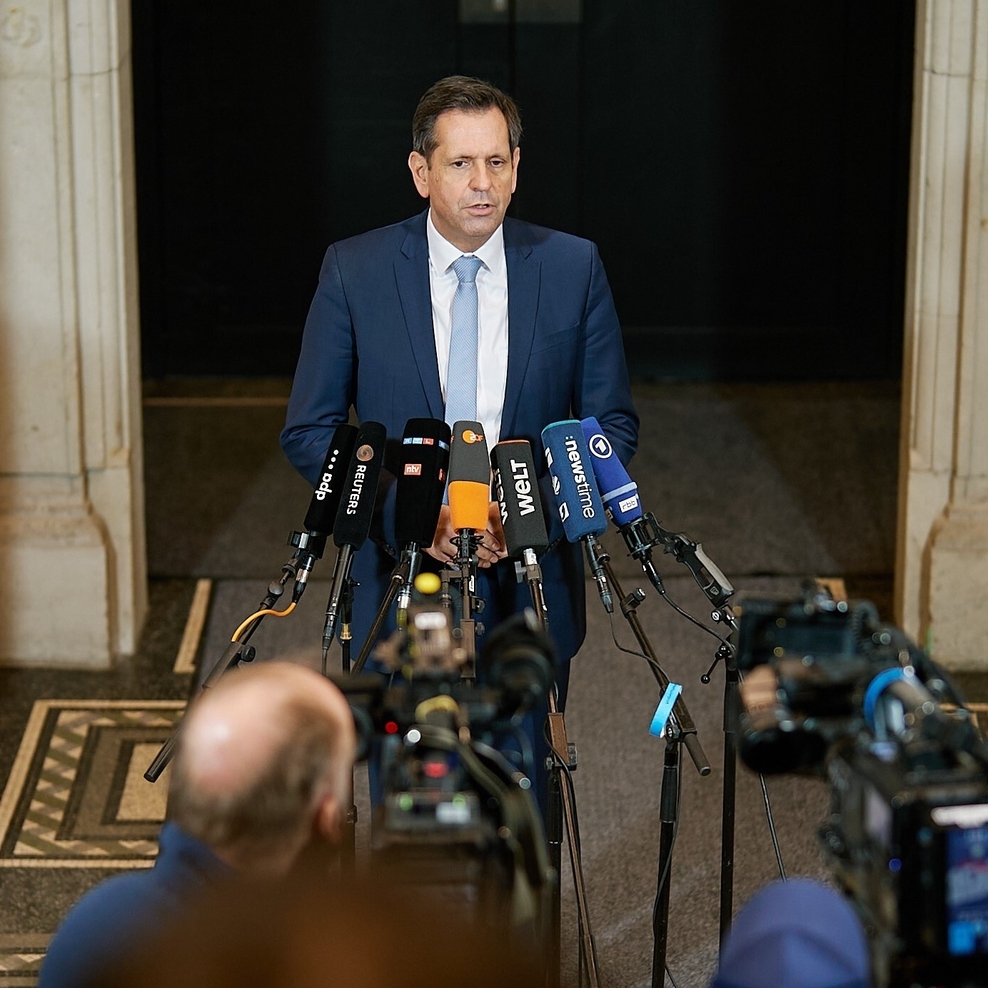 Ministerpräsident Olaf Lies vor vielen Mikrofonen und Kameraleuten.