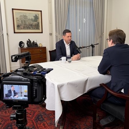 Ministerpräsident Olaf Lies und IHK-Hauptgeschäftsführer Malte Heyne sitzen an einem weiß gedeckten Tisch vor Mikrofonen und sprechen miteinenander. Im Vordergrund ist eine Kamera von hinten zu sehen, die den Podcast aufzeichnet.