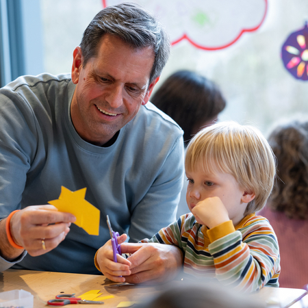 Olaf Lies bastelt mit einem Kind.