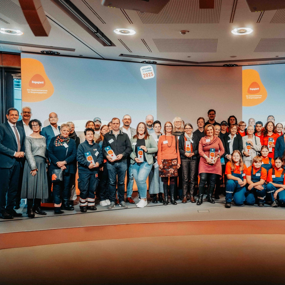 Die Preisträgerinnen und Preisträger stehen mit den Ausrichtenden des Preises auf der Bühne