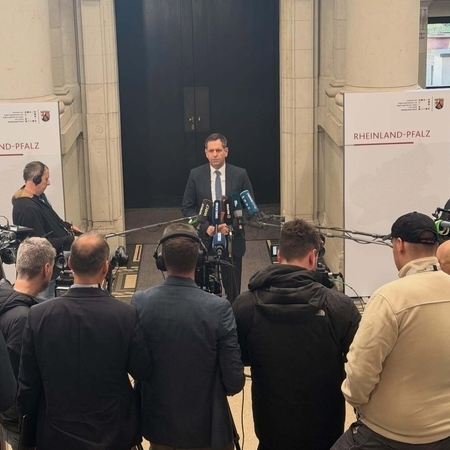 Ministerpräsident Olaf Lies steht vor Medienvertretern und hält ein Statement.