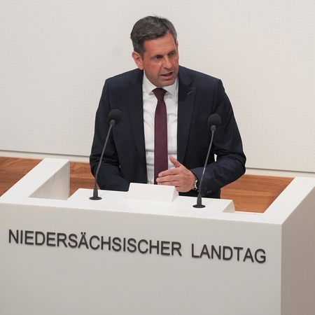 Ministerpräsident Olaf Lies steht am Rednerpult vor dem Niedersächsischen Landtag und adressiert die Abgeordneten.